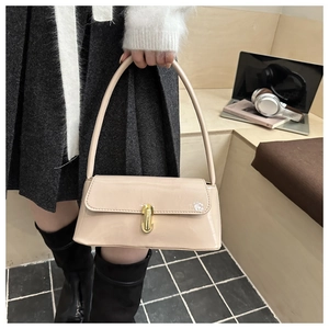 Détail du sac sous le bras en cuir verni crème avec boucle dorée et rabat carré
