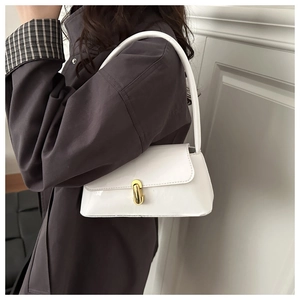 Détail d'un sac à bandoulière en cuir verni blanc avec boucle ovale dorée
