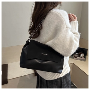 Detail of black matte shoulder bag with silver chain strap and modern brand lettering