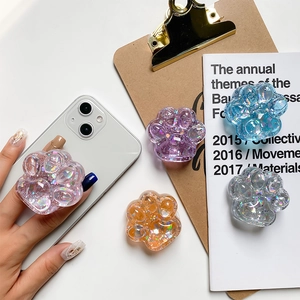 Close-up of glitter cat paw phone grips in pink, purple, blue, and orange colors