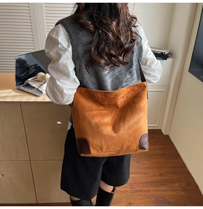 Detail of vintage brown suede tote bag featuring reinforced leather corners for daily use