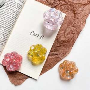 Macro detail of cat paw phone grips with glitter and star sequins in four vibrant colors