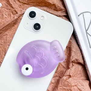 Close-up of cute purple fish-shaped phone grip with matte finish on a white smartphone
