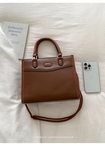 Vue de dessus d'un sac à main marron vintage minimaliste avec poignées et bandoulière