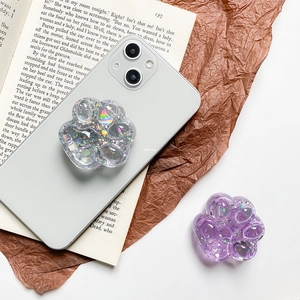 Close-up of glittery cat paw phone sockets with holographic sequins in purple and clear