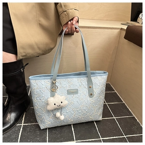 Detail of light blue star-quilted tote bag featuring a cute cloud plush charm