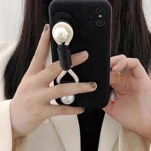 Detail of pearl wrist strap on black leather base for phone case hand grip support