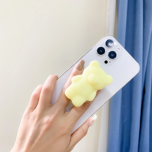 Hand holding phone with yellow 3D cartoon bear expandable grip stand on white case