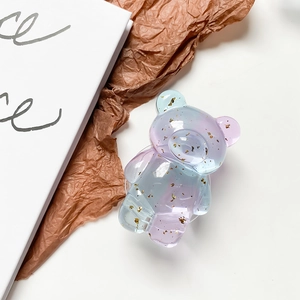 Close-up of bear-shaped gradient purple and blue phone grip with gold foil flakes