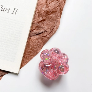 Close-up of pink cat claw phone grip featuring glitter and laser sequins in resin