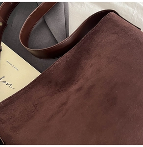 Detail of dark brown suede tote bag showing premium matte texture and smooth leather strap