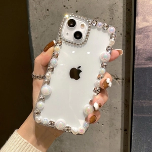 Detailed view of luxury iPhone case with faux pearls and rhinestones held by a hand