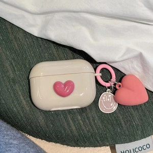 Detail of cream silicone AirPods Pro case with 3D pink heart and matching charm