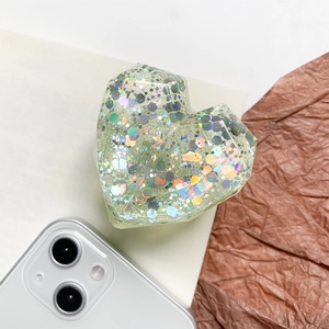 Detail of 3D faceted heart phone socket with iridescent sequins on a white background