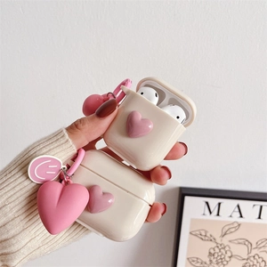 Detail of cream silicone AirPods case with 3D pink heart and matching oversized pendant