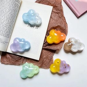 Macro detail of cloud-shaped resin phone stands with gold foil in gradient colors