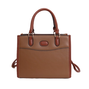 Vintage brown leather contrast handbag with top handle and gold hardware on white background
