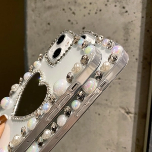 Detail of luxury iPhone case featuring large heart mirror and handmade pearl rhinestones