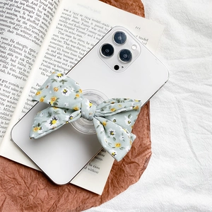 Supporto per cellulare pieghevole con fiocco floreale verde su smartphone bianco