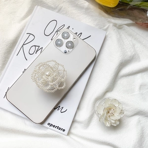Elegant 3D rose phone grip with pearls and resin petals on a minimalist white iPhone