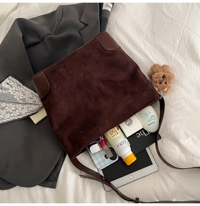 Macro shot showing large storage capacity of brown suede tote bag with daily essentials
