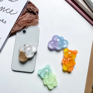 Detail of glitter bear and cloud phone socket grips with gold foil and resin texture