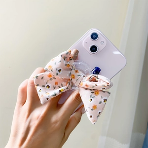 Dettaglio del supporto per telefono a fiocco in tessuto con stampa floreale vintage rosa