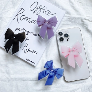 Vue à plat de supports de téléphone en forme de nœud en noir, violet, bleu et rose