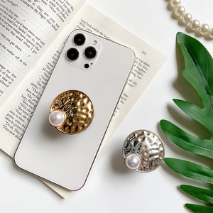 Chic folding phone socket with hammered metal finish and pearl accent on white smartphone
