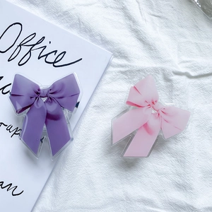 Détail des supports de téléphone en acrylique en forme de nœud rose et violet