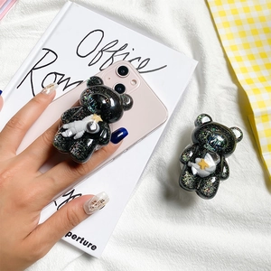 Close-up of cute black glitter bear phone socket with tiny astronaut detail for desk use