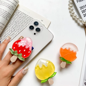 Detailed view of three resin fruit ice cream phone grips with strawberry and orange slices