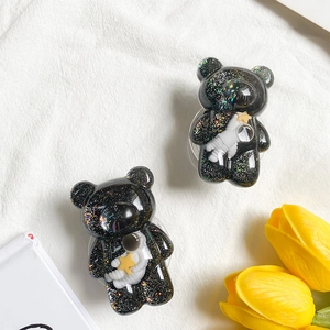 Sparkly glitter bear phone holder with astronaut and star relief on white background