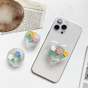 Close-up of cute floral acrylic phone grip stands in heart and round shapes