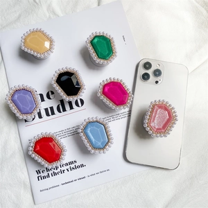 Flat lay of multiple colorful gemstone phone grips with pearl and crystal edge decorations