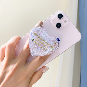 Macro detail of heart-shaped phone grip with silver glitter and I Love You text