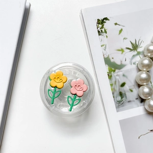 Close-up of pink and yellow tulip floral phone socket grips on a minimalist background