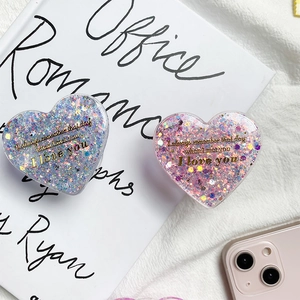 Macro detail of heart-shaped glitter phone grips with I love you text and sequins