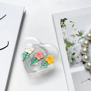Detail of heart-shaped tulip phone grip with 3D floral accents on white background