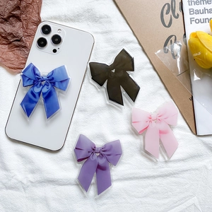 Poignées de téléphone élégantes avec nœud en soie en quatre couleurs sur tissu blanc