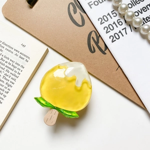 Detail of yellow peach popsicle phone grip featuring a glossy resin finish and wood stick