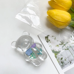 Detail view of transparent bear phone socket with embedded purple and blue flowers