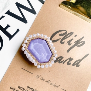 Close-up of purple glitter resin grip tok with pearl inlay and diamond accents