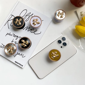 Macro detail of electroplated bowknot phone grips with gold bead trim in various colors
