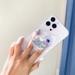Detail of a transparent heart-shaped phone grip with 3D tulip floral patterns on a phone