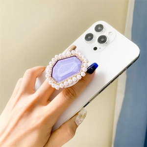 Macro detail of purple glitter hexagonal phone grip with faux pearl and rhinestone trim