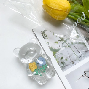 Detail of transparent bear phone socket with cute smiling flower resin accessories