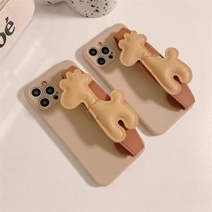 Détail de la coque iPhone avec dragonne en cuir marron et breloque chien en 3D