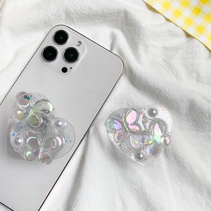 Macro view of heart-shaped phone grip with holographic butterfly and pearl details