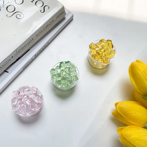 Three multi-colored faceted crystal phone socket grips in pink green and yellow colors